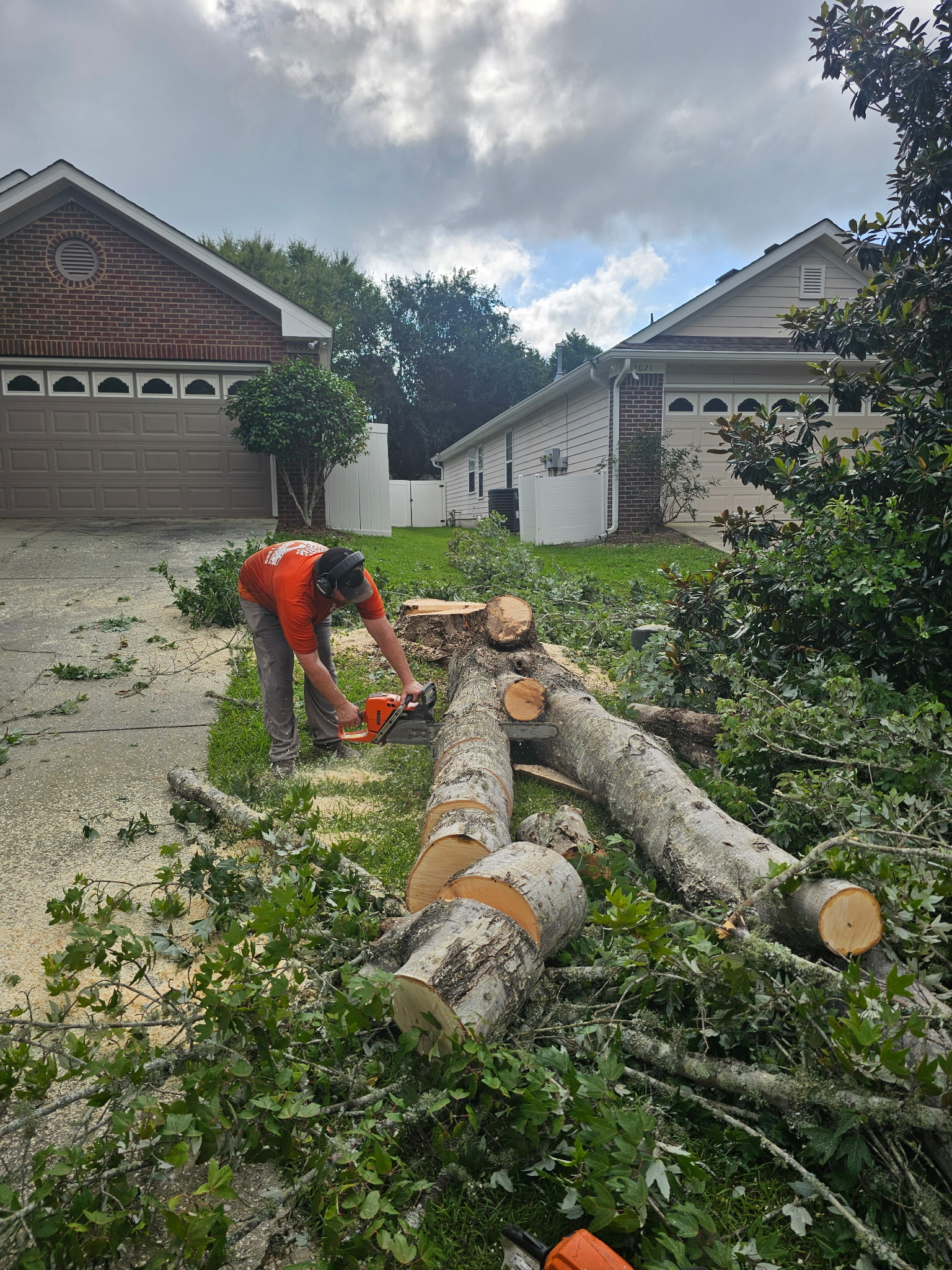 H&L crew cutting a large tree trunk at a residential property